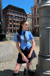 a lady in a blue shirt and a black skirt
